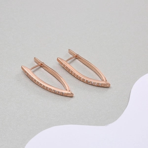 Macro detail of rose gold U-shaped earrings with micro-set cubic zirconia stones
