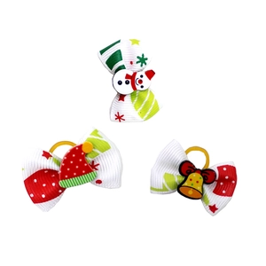 Detailed view of Christmas pet hair bows with snowman, hat, and bell resin accessories
