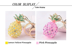 Close-up of crystal pineapple keychains in yellow and pink with gold plating