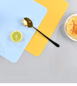 Detail of light blue and yellow silicone placemats showing heat-resistant properties
