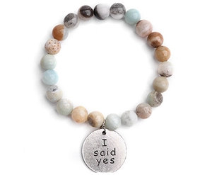 Detail of natural stone beaded bracelet featuring a round charm with I Said Yes engraving