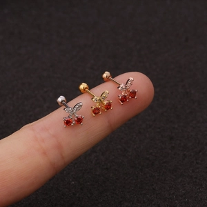 Creative cherry zircon earrings in silver, gold, and rose gold on a finger display