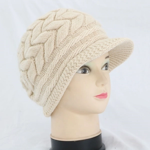 Dettaglio del berretto in maglia beige a doppio strato con motivo a trecce e pelo di coniglio