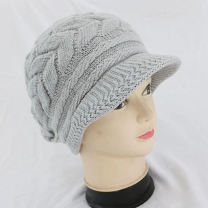 Dettaglio laterale del berretto grigio in maglia a trecce con visiera per l'inverno