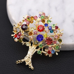 Detailed view of golden tree brooch with colorful rhinestones on a macro background