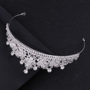 Detailed view of silver bridal crown with white rhinestones and leaf pattern design