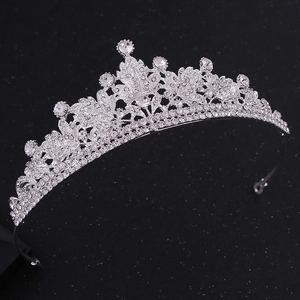 Macro shot of silver bridal tiara featuring leaf-shaped crystal rhinesones on black background