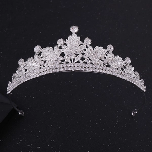 Detailed view of silver bridal crown featuring crystal leaf patterns on a dark background