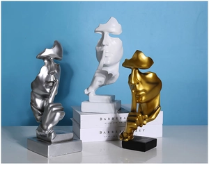 Close-up of Nordic silence-themed sculptures in gold, silver, and matte white finishes