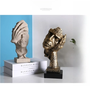 Detail of creative abstract face sculptures in sandstone and vintage gold resin on books