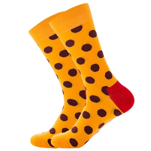Détail de chaussettes en coton jaune à pois marrons avec talon rouge renforcé