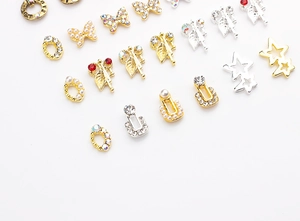 Close-up of mixed alloy nail charms featuring butterfly shapes and rhinestone accents