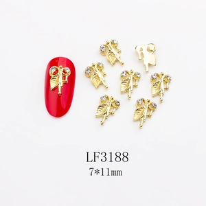 Detailed view of 7x11mm gold leaf alloy nail charms with sparkling white rhinestones