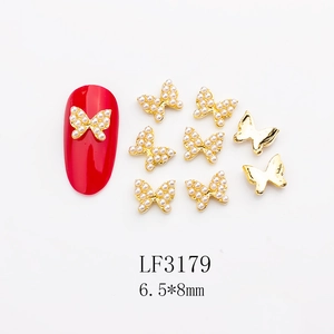 Detailed view of golden butterfly nail charms with pearls and 6.5x8mm size info