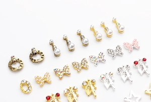 Detailed view of assorted 3D nail art charms with pearls, rhinestones, and butterfly designs