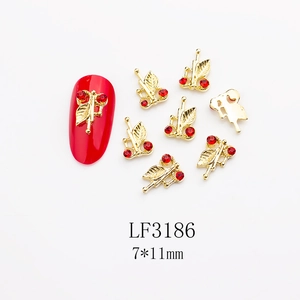 Detailed macro view of cherry nail art charms with red rhinestones and gold alloy metal