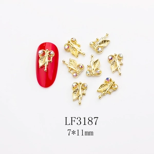 Detail of 7x11mm golden butterfly nail charm with colorful rhinestones on red nails