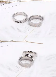 Macro detail of silver stainless steel rings with I Love You engraving on white feathers
