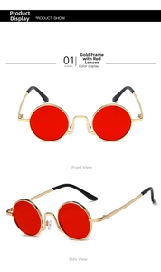 Detail view of vintage gold metal round sunglasses with vibrant red tinted lenses