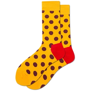 Détail de chaussettes jaunes à pois marrons avec talons et orteils rouges contrastants