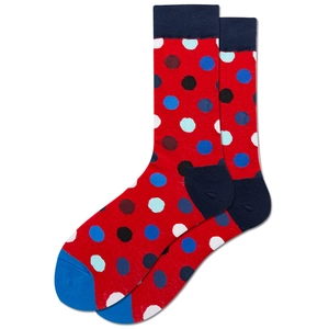 Vue macro de chaussettes en maille rouges à pois multicolores sur un fond blanc pur
