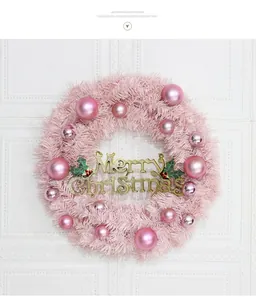 Detailed view of a pink Christmas wreath with gold Merry Christmas sign and shiny ornaments