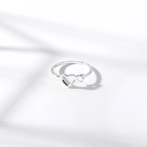 Close-up of silver adjustable ring featuring two minimalist hollow heart-shaped designs