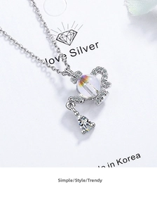 Macro shot of silver teapot pendant necklace featuring crystal sphere and zircon drop details