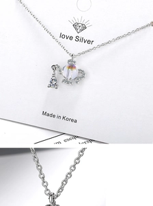 Detail of silver teapot pendant with crystal bead and sparkling rhinestones on jewelry card