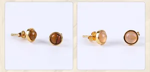 Detailed close-up of gold-plated tiger eye and moonstone stud earrings in round bezel setting