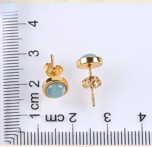 Macro detail of 8mm light blue gemstone stud earrings with measurement scale