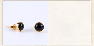 Detailed view of round black gemstone stud earrings with elegant gold plated metal borders