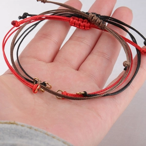 Close-up of adjustable handmade wax cord bracelets in red, black, and brown colors