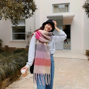 Detailed texture of rainbow plaid cashmere scarf with soft fringes and colorful tassels