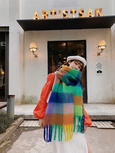 Close-up of thick knit rainbow plaid scarf with long tassels and vibrant checkered pattern