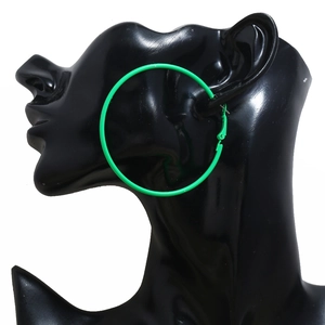 Close-up of vibrant green oversized hoop earrings worn by a model for a retro 80s style