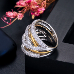 Macro detail of intertwined two-tone wide ring with micro-pave white zircon stones