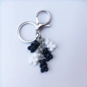 Detailed view of silver metal keychain rings with black and white resin gummy bear charms