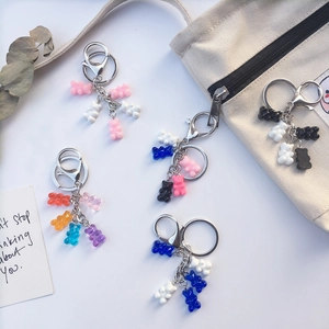 Colorful resin gummy bear keychains with silver metal rings on a minimalist background
