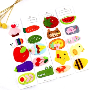 Detail of handmade felt hair clips with cute fruit and animal shapes on display cards