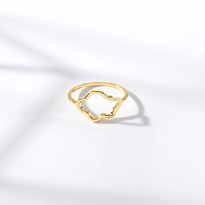 Detail of gold zircon ring with hollow cloud design on a natural shadow background