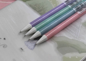 Close-up of four colorful cartoon mechanical pencils in purple, green, blue, and pink colors