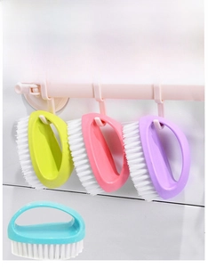 Dettagli macro di spazzole ergonomiche per bucato in vari colori con fori per appendere
