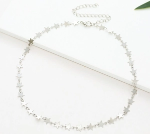 Detailed close-up of a silver pentagram star necklace on a minimalist white platform