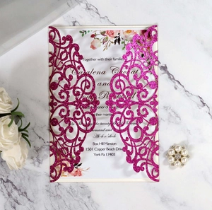 Detail of rose red glitter laser cut wedding invitation with inner card on marble surface