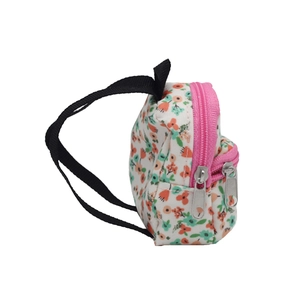 Detailed side view of a floral doll backpack with pink zippers and black straps