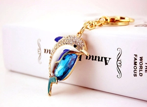 Detail of a dolphin keychain with blue crystal and shimmering clear rhinestones