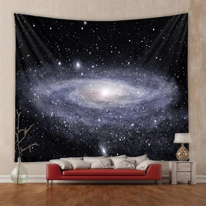 Detailed view of cosmic spiral galaxy tapestry hanging behind a red sofa in modern living room