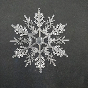 Macro shot of a clear snowflake hanging ornament with intricate crystalline textures