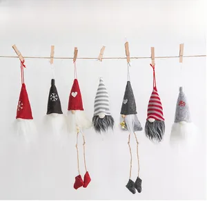 Close-up of Nordic Christmas gnome felt ornaments hanging on a rope with wooden clips